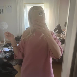 Rosa stickad tröja från 157 - Mysig rosa stickad tröja från 157 med rund halsringning och lite vidare ärmar. Perfekt för att hålla sig varm och snygg under kyligare dagar. Enkel och stilren design som passar till mycket.