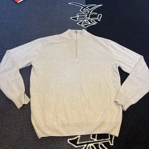 Beige Kashmir halvzip-tröja från Oscar Jacobson - Säljer en stilren beige halvzip-tröja från Oscar Jacobson. Tröjan har lång ärm, hög krage med dragkedja och är tillverkad i mjukt material. Perfekt för lager-på-lager och passar till många olika outfits.