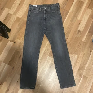 Grå jeansbyxor från H&M - Säljer ett par grå jeansbyxor från H&M med straight regular fit. Klassisk femficksmodell och normal passform, perfekta för dig som gillar enkel och stilren look. Midjan är normal och materialet är mjukt denim. Storlek är 32/34 och priset kan diskuteras.