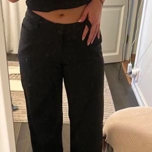 Svarta kostymbyxor med normal passform - Säljer ett par svarta kostymbyxor med normal passform och raka ben. Byxorna har låg midja, knäppning fram och fickor bak.💗