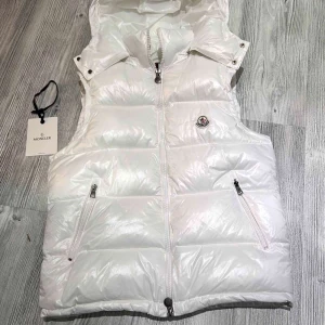 Moncler väst - Hej! Jag säljer nu min moncler väst som är i nyskick den är andvänt väldigt sparsamt och inte alls länge, den är absolut äkta och köpt ifrån Nk kvittot finns som bevis till det och nfc Scan funkar som den ska. original tillbehören ingår med västen som lapparna osv, priset är hugget i Sten hör av dig vid minsta lilla fråga!😄