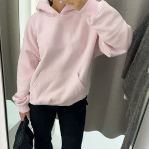 Ljusrosa hoodie - Säljer en oversized ljusrosa hoodie med huva och långa ärmar. Tröjan har en klassisk känguruficka framtill och ribbade muddar vid ärmslut och nederkant. Perfekt för en avslappnad och bekväm stil. Den är ny och aldrig använd❤️Pris kan diskuteras. 