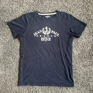 Jean Paul T-shirt - En fet Jean Paul T-shirt! Tröjan har ett litet hål som ni kan se på bild 3, annars jätte fint skick, 8/10. Storlek S. Hör av er vid minsta!💫