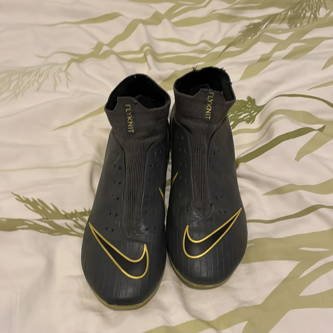 Svarta Nike fotbollsskor med gula detaljer