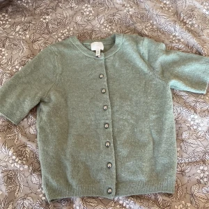  stickad kortärmad töja -  Mint grön stickad tröja som är kortärmad med silvriga knappar, jättefin till ett par jeans eller en kjol på kvällarna i sommar !❤️💕säljer pågrund av att den aldrig har andvänts💋