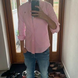 skjorta Polo Ralph Lauren - Snygg rosa skjorta från Polo Ralph Lauren i slim fit-modell. Skjortan har klassisk krage, knappar framtill och långärmade ärmar med uppvik. Perfekt för skolan nu och lite finare tillfällen🙌 den är lite för liten på mig på bredden, armarna och längden. Är typ 172 och väger 59. Så skulle kunna passa nån som är typ lite under 170 antar jag. Ställ frågor och pris kan diskuteras😀