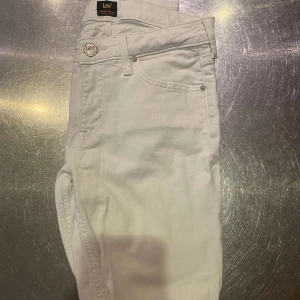 Vita jeans Scarlett från Lee W28 L31 - Snygga vita jeans från Lee i modellen Scarlett. Klassisk femficksdesign med Lee-logga på knapp och bakficka. Jeansen har en smal passform och är tillverkade i mjuk bomull med lite stretch för extra komfort. Perfekta för dig som gillar stilrena outfits. Hör av er om minsta fundering! (Pris kan diskuteras vid snabb affär)