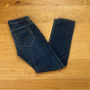 Dondup George  - Snygga mörkblå Replay Anbass jeans med klassisk femficksdesign och kontrastsömmar. Modellen har en slim passform och raka ben, tillverkade i mjukt jeansmaterial med stretch för extra komfort. Perfekta för dig som gillar stilrena och tidlösa jeans.