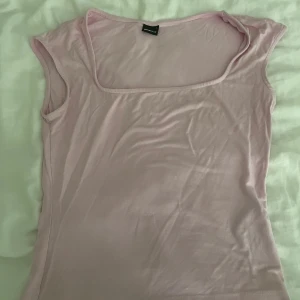 Ljusrosa linnetopp med fyrkantig hals - Supersöt ljusrosa linnetopp från Gina Tricot med en snygg fyrkantig halsringning och ärmlös design. Tunn och mjuk bomull som känns skön mot huden. Perfekt att matcha med jeans eller kjol för en chill look.