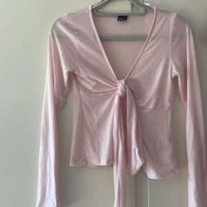 Ljusrosa omlottopp från Gina Tricot - Supersöt ljusrosa omlottopp från Gina Tricot med lång ärm och snygg knyt framtill. Säljer denna för jag ej använder den längre💕köpte för 400 men säljer för 80