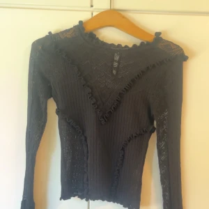 Virkad svart långärmad festtopp - Knappar i nacken. Säljer då den är för liten. Storlek Xs. Tar emot bud. Inga defekter. Köpt på vinted och vet ej märke men tror zara.