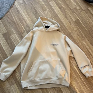 Essientals Hoddie - Beige Essientals Hoodie, säljs pga av för liten. Nypris 1799kr. Passar perfekt för dig som e runt 175-180cm. Pris kan diskuteras.!