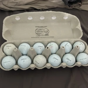 Golfbollar  - Bilden visar en äggkartong fylld med golfbollar av märket Titleist. Utan sponsorer.