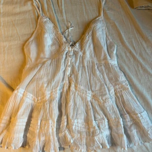 Vit gulligt linne - säljer en super söt linne med fina detaljer med snören och knappar på, den är ifrån Urban Outfiters och är helt oanvänd, jätte gullig att ha nu i höst eller nästa sommar. storleken vet jag inte eftersom de inte står men skulle gissa på S, passar XS och M också. priset kan diskuteras :)
