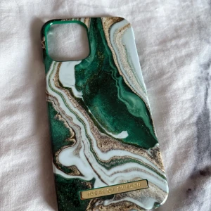 Mobilskal (iDeal of Sweden) - Snyggt mobilskal från Ideal of Sweden med marmormönster i grönt, vitt och guldiga detaljer. Skalet är magnetiskt. Nypris 300kr. Går att prova prisförslag då jag vill få alla skal sålda pga ny telefon🤗  .