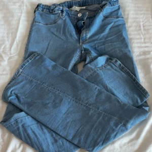 Blå raka jeans i klassisk modell - Snygga ljusblå jeans med rak passform och klassisk femficksdesign. Jeansen har normal midja och är tillverkade i mjukt denimtyg som är skönt att bära hela dagen. Perfekta för dig som gillar en enkel och tidlös stil.