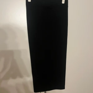 Svart tajt långkjol - Säljer en stilren svart långkjol med rak passform. Kjolen är enkel och tidlös, tillverkad i ett mjukt och stretchigt material som sitter bekvämt. Knappt använd och är i ett fint skick! Sitter snyggt och bra💞