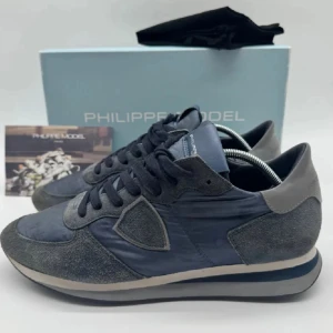 Grå sneakers från Philippe Model - Snygga blåa sneakers från Philippe Model med en stilren design. Storlek 42 men i vissa fall kan passa 43. Bra skick 8/10. Hör av er för fler bilder! Box medföljer!