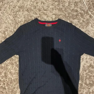 Morris Ethan Cable Oneck - Rundhalsad - Stilren sweatshirt från Morris i mörkblått. Skön bomullskvalitet, klassisk passform och ikonisk logga framtill. Perfekt för både vardag och avslappnade tillfällen. Skriv med ägare innan köp