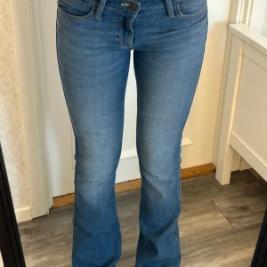 Lågmidjade utsvängda jeans  - Jätte snygga jeans från Lee! De är lågmidjade och utsvängda! Storleken i dom är W27 L33 men måtten är: Innerben: 82 cm, midja rakt över: 38 cm Kom privat för fler mått eller frågor🥰