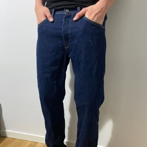 Levis 501 - Säljer ett par mörkblå Levis jeans. De har en rak passform och är perfekta för vardagsbruk. Jeansen har en dragkedja och knappar framtill. De är i bra skick och passar till de flesta outfits.