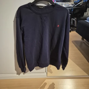 Mörkblå sweatshirt från Replay - Snygg mörkblå sweatshirt från Replay med diskret röd broderad logga på bröstet. Tröjan har rund hals, långa ärmar och är gjord i mjuk bomull. Perfekt för chill dagar och enkel att matcha med jeans eller joggers. Priset ej hugget I sten