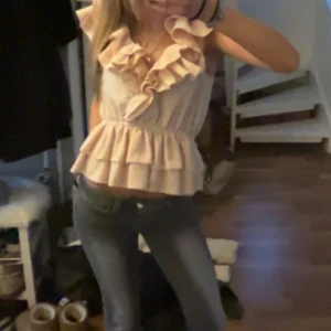 Ljusrosa volangblus med v-ringning - Supersöt ljusrosa blus med v-ringning och stora volanger både vid halsen och nederkanten. Blusen är croppad och har en loose passform som ger en chill vibe. Perfekt för dig som gillar romantiska detaljer och vill sticka ut lite extra. Kom privat för fler bilder!