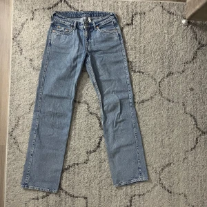 Blå jeans från Weekday - Snygga blå jeans från Weekday med klassisk design. De har en rak passform och är perfekta för en avslappnad stil. Jeansen har en knappgylf och femficksmodell.