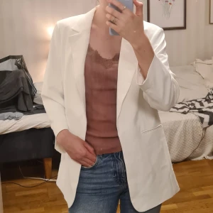 Vit kavaj från H&M - Säljer en stilren vit kavaj från H&M i storlek 40. Kavajen har en klassisk design med dekorativa fickor och har endast andvänts en gång. Denna gång lyckades den däremot få några små fläckar som jag gärna skickar bild på ifall du önskar. Fläckarna är små så det var svårt att få med bild på dem😊