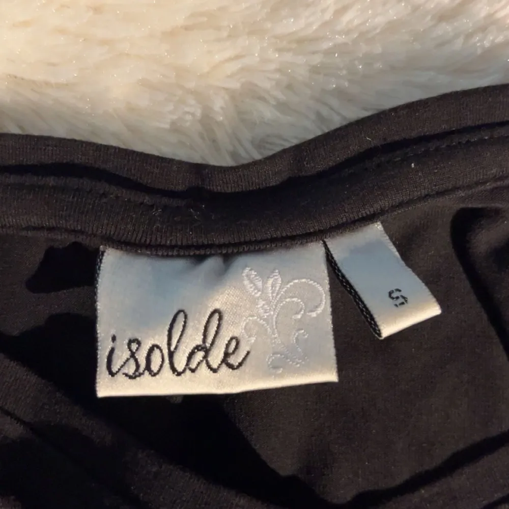 Säljer en stilren svart långärmad tröja från Isolde. Perfekt för en enkel och klassisk look. Tröjan har en rund halsringning och är gjord i ett mjukt material som känns skönt mot huden.. Neuletakit & Villapaidat.
