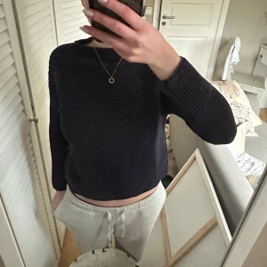 Marinblå ribbad tröja - Säljer en marinblå ribbad tröja med lång ärm. Tröjan har en croppad passform som ger en modern look. Perfekt för en avslappnad stil.