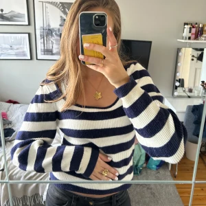 Stickad tröja från Mango - Säljer en snygg randig tröja från Mango i marinblått och vitt. Tröjan har en fyrkantig halsringning och långa ärmar.Den är ribbad och ger en skön passform. Använd men i bra skick!