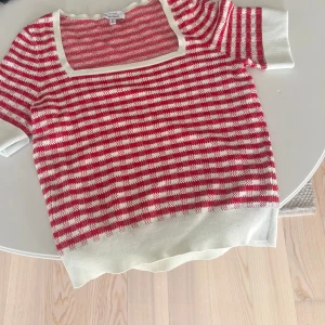 Röd och vit randig topp - Säljer en söt röd och vit randig topp med korta ärmar och fyrkantig halsringning. Storlek M men passar s och xs också och ger en lite avslappnad passform.