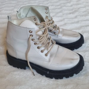 Vita boots med snörning - Snygga vita boots med kraftig svart sula och snörning. I fint skick