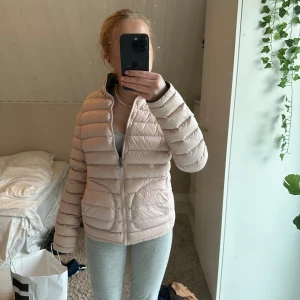 Vändbar dunjacka från Oui - Säljer en snygg vändbar dunjacka från Oui. Ena sidan är ljusrosa och den andra är svart. Jackan har en dragkedja framtill och långa ärmar. Perfekt för vårväder.  Pris kan diskuteras 