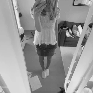 Vit blus från Odd molly - Charmig vit blus med korta ärmar och vackra broderade detaljer. Blusen har en luftig passform och en söt knytning i ryggen. Perfekt för en avslappnad och stilren look.