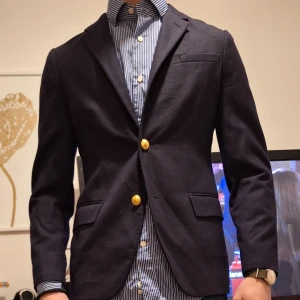 Mörkblå kavaj från Polo Ralph Lauren - Snygg mörkblå kavaj från Polo Ralph Lauren med guldknappar. Perfekt för en stilren look. Tillverkad i Italien och passar bra till både skjorta och jeans. Utlagd i ärmen hos skräddare Nypris Ca 5000kr