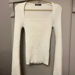 Vit stickad tröja från Gina Tricot - Säljer en stilren vit ribbad tröja från Gina Tricot. Tröjan har en fyrkantig halsringning och långa ärmar, perfekt för en chic look. Passar utmärkt till både jeans och kjol. Använd fåtal gånger och har inga defekter. Perfekt nu till våren!!!🌸
