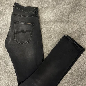 Nudie jeans grim tim - Snygga svarta jeans från Nudie Jeans med en klassisk femficksdesign. Modellen är grim Tim och de är i suveränt skick. Jeansen är sprillans nya, köpta för 1800kr, säljer för endast 529kr (pris kan diskuteras vid snabb affär). Storlek: 31/34. Tveka inte på att höra av er vid frågor:)