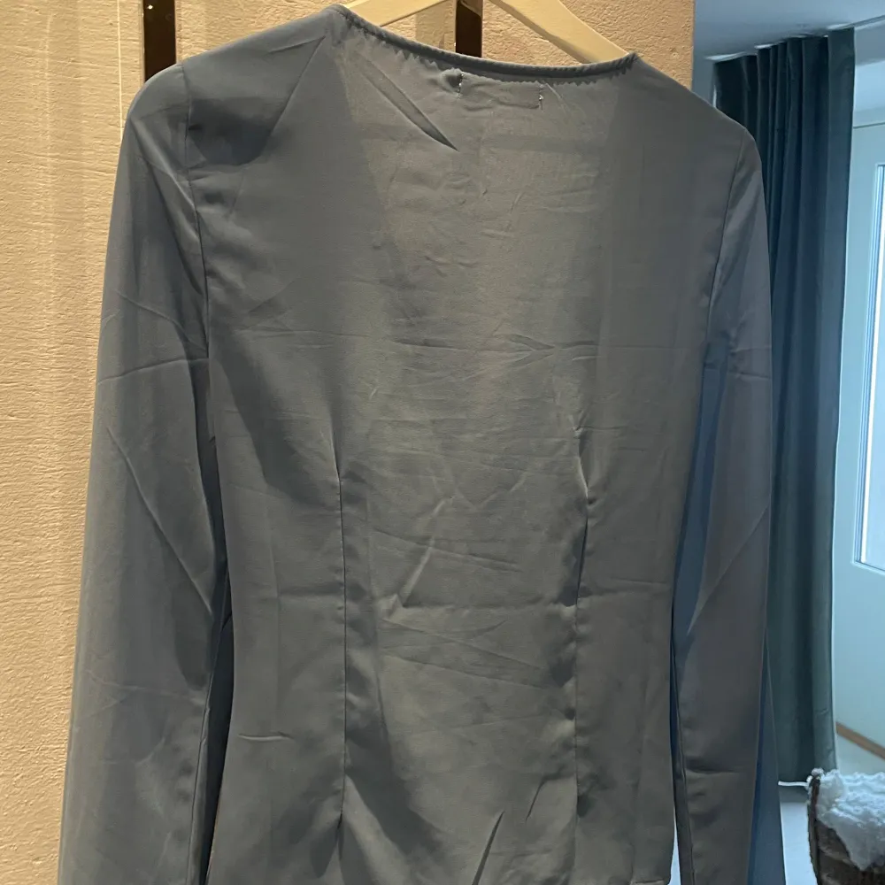 Säljer en söt blå blus från NA-KD med lång ärm och knytning framtill. Sparsamt använd. Blusen är lite skir, alltså lite genomskinlig.. Puserot.