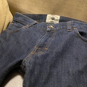 Mörkblå jeans från tiger of Sweden - Snygga mörkblå jeans från Tiger of Sweden med klassisk femficksdesign och knappgylf. Perfekta för dig som letar efter en grisch/Laidback stil. Men som vill hitta det för en bättre budget. Jeansen og pris ligger runt 1600kr och jag säljer dem för 420kr. Jeansen är i ett bra skick men använda. (Jeansen är 33/34 i storlek, men passar som 32-32).Priset är ej hugget i stenen, och för minsta lilla fundering/fråga så är det bara att fråga på.