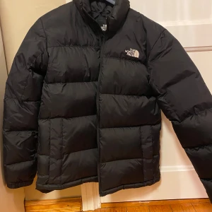 Svart dunjacka North Face - Säljer en svart dunjacka från North Face. Originalpris 3500 kr.