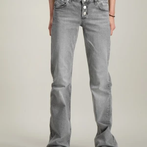 Grå bootcut jeans - Snygga grå bootcut jeans med hög midja och knappar framtill. Perfekta för en avslappnad stil med en touch av retro. De har en klassisk femficksdesign och är tillverkade i ett bekvämt denimtyg. Original pris 349 men jag säljer för 250 kr. Bara använd några gånger. Storlek 152, men passar även dig som är runt 158 cm- sitter perfekt på mig!