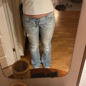 Blå jeans med slitna detaljer - Midjemått: 42 cm Innerbenslängd: 84 cm, har sytt igen hålet men kan tas upp igen utan att man ser de!!