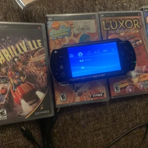 Psp med spel och laddare  -  PSP där du kan uppleva spänningen av en nöjespark med olika karnevalspel. Perfekt för dig som gillar utmaningar och roliga minispel. Utforska olika attraktioner och samla poäng för att vinna priser.