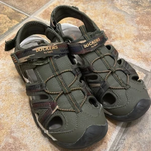 Gröna sandaler från Dockers str 35 - Snygga gröna sandaler från Dockers str 35 med justerbara remmar och robust sula. Perfekta för sommarens äventyr med en bekväm passform och slitstarkt material.