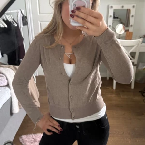 Beige kofta med knappar - Säljer en stilren beige kofta med knappar framtill. Koftan har långa ärmar och en klassisk rund halsringning. Så mjuk och skön!💋💓