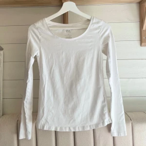 Vit långärmad topp från 157 - Säljer en stilren vit långärmad tight topp från Lager 157 i storlek S. Perfekt basplagg med rund halsringning, tillverkad i mjuk bomull för en bekväm passform. Passar utmärkt till lager-på-lager eller som den är. 🕊️