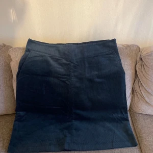 Mörkblå/grön manchesterkjol från Gudrun Sjödén - Snygg mörkblå/grön manchesterkjol från Gudrun Sjödén. Kjolen har en elastisk midja för extra komfort och är perfekt för en stilren look. Den är tillverkad i ett mjukt manchestermaterial som ger en härlig textur. Två fickor 