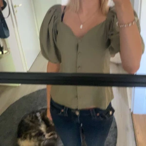 Olivgrön blus med puffärmar  - Supersnygg olivgrön blus med stora puffärmar och v-ringad hals. använd fåtal gånger. skriv för fler bilder eller frågor💕